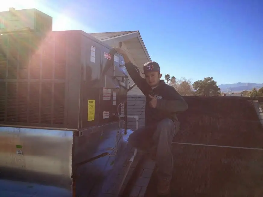 HVAC technician performing Air Duct Cleaning on a rooftop unit in Lone Tree